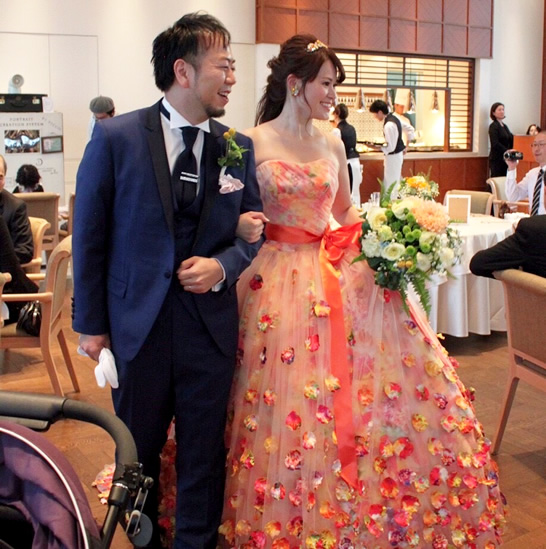 ネイビーのタキシードとオレンジのカラードレスがお似合いの内田様ご夫妻です