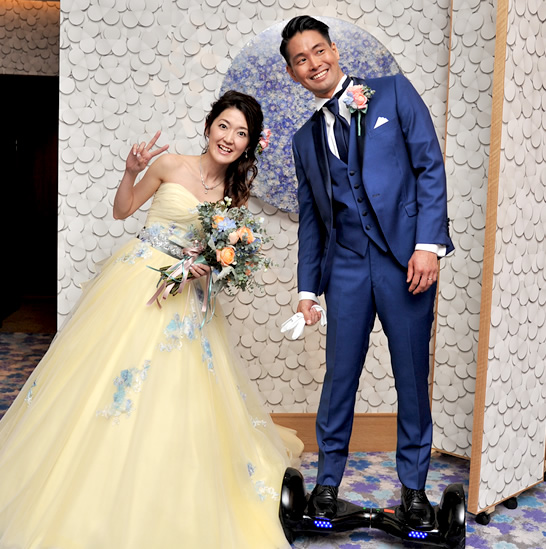 ネイビーのタキシードとイエローのカラードレスがお似合いの望月様ご夫妻です