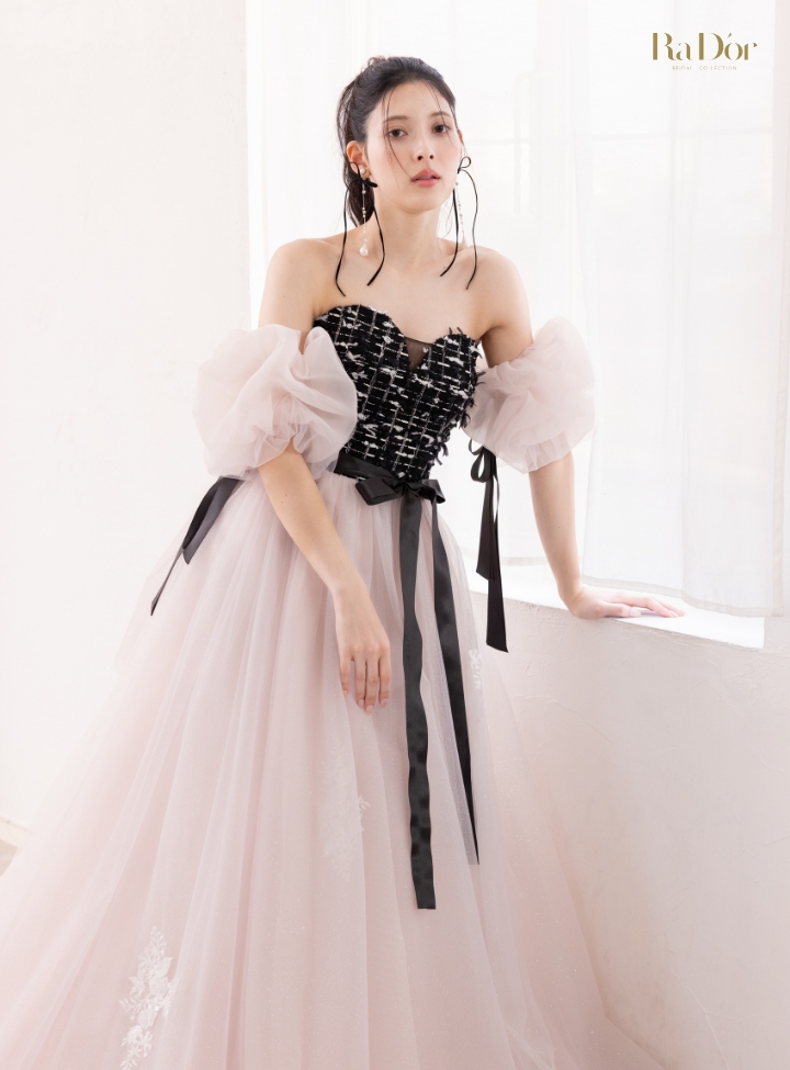 黒ツイードとピンクのチュール素材のコントラストが印象的なパフスリーブドレスを着た花嫁の全身イメージ
