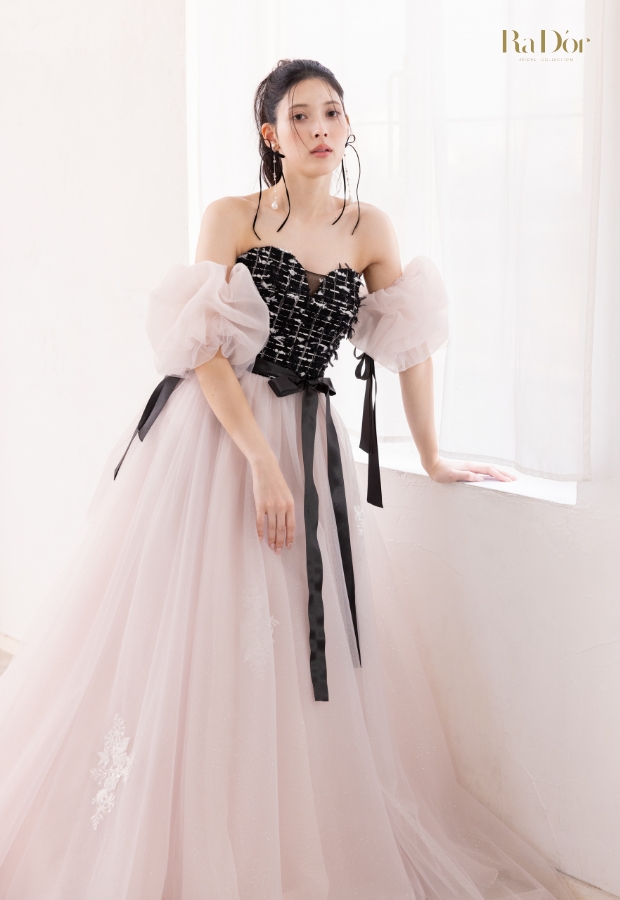 黒ツイードとピンクのチュール素材のコントラストが印象的なパフスリーブドレスを着た花嫁の全身イメージ