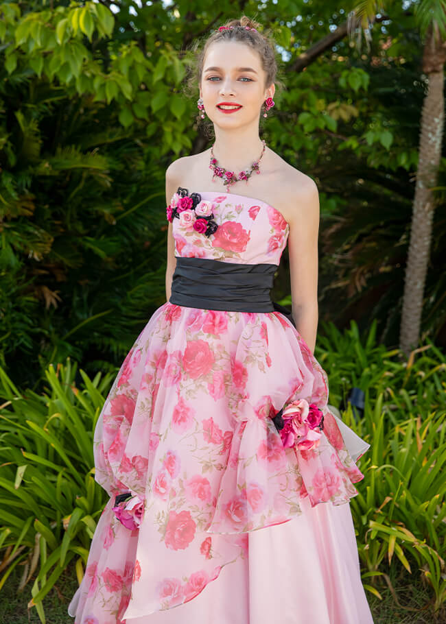 バラのプリントが施された可愛らしい印象のピンクのドレスを着た花嫁のアップイメージ