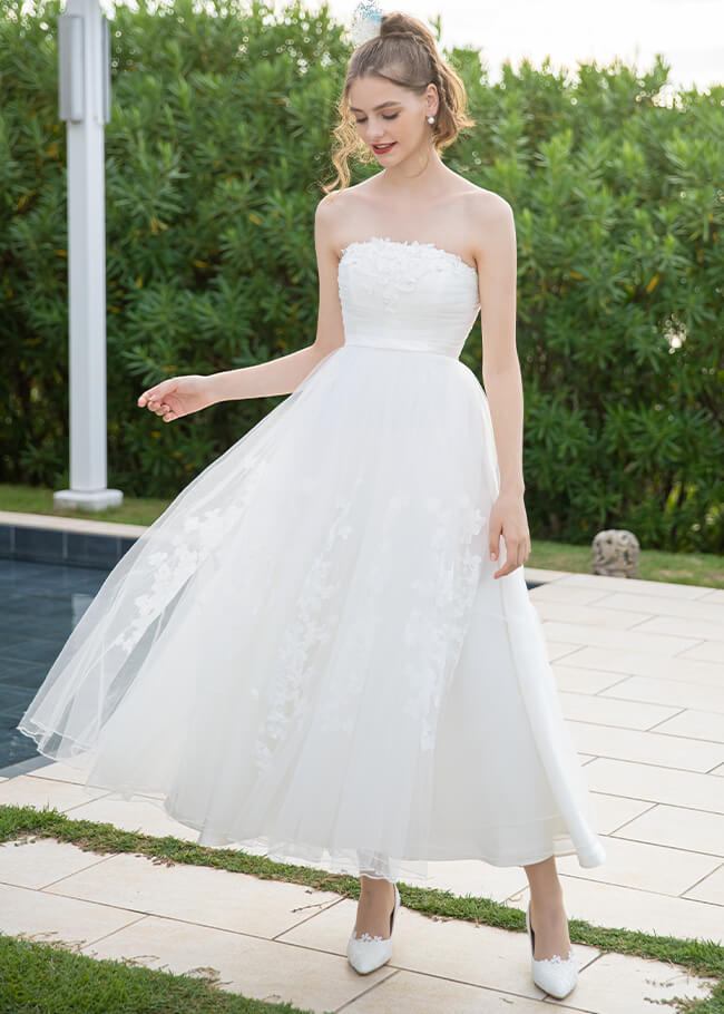 リゾートの軽やかな印象を引き立てるミモレ丈のウェディングドレスを着た花嫁