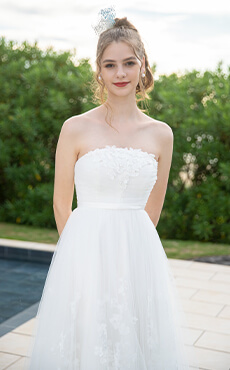 リゾートの軽やかな印象を引き立てるミモレ丈のウェディングドレスを着た花嫁のアップイメージ
