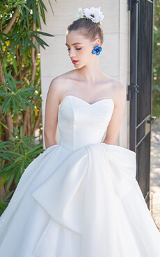 大きなリボンモチーフが特徴的な白のプリンセスラインのドレスを着た花嫁のアップイメージ