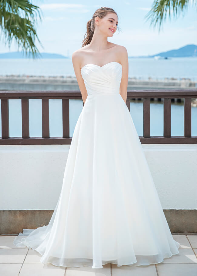 シンプルなデザインで軽やかな印象のスレンダーラインのドレスを着た花嫁