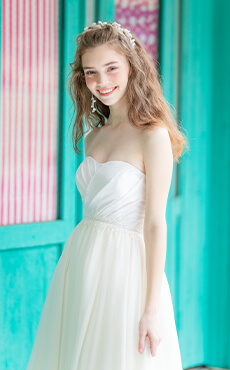 軽やかでスリムなアイボリーのスカートが印象的なAラインウェディングドレスを着た花嫁のアップイメージ